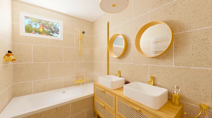 Salle de bain à Bonchamp-lès-Laval : double vasque, miroirs ronds et robinetterie dorée